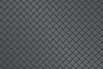 Dark gray diamond-plate metal texture with light gray crisscross pattern. Overhead view, seamless industrial background for grunge, machinery, or rugged design projects. Neutral lighting.