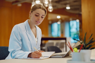 In a chic and stylish office setting, a dedicated healthcare professional diligently writes notes...