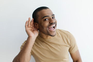 Curious Cheerful Black Man Holding Hand Near Ear Trying To Overhear Something, Excited Young...