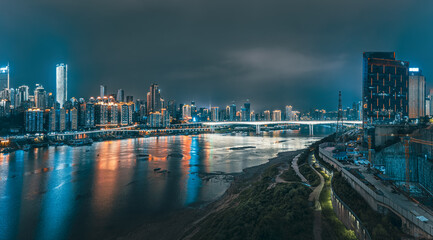 Panoramic of the sprawling modern city skyline illuminated at night with multiple bridges crossing...