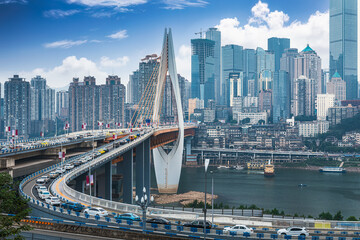 Busy traffic flows over a modern cable-stayed bridge and city skyline in Chongqing, China.