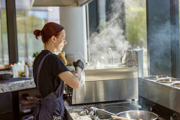 A talented chef adeptly showcases their culinary skills while skillfully cooking in a modern, vibrant kitchen space