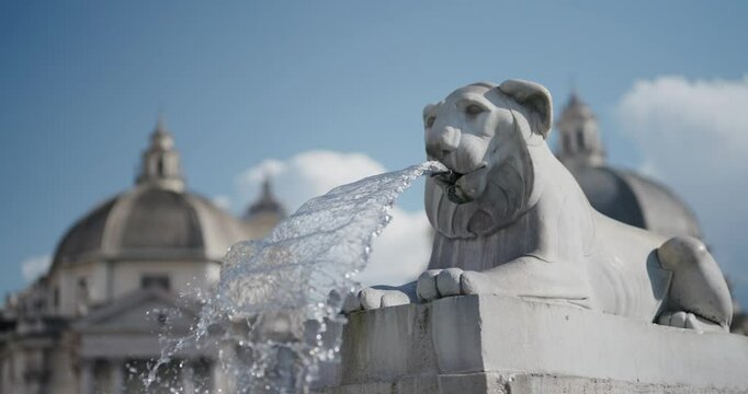 Cinematic establishing shot the water flowing in slow moiton from the lion fountain on the Piazza del Popolo in Rome, Italy, selective focus isolated shot