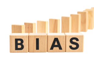 Wooden blocks spell out "BIAS" with domino pieces arranged behind them.