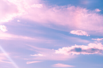Beautiful pink and blue pastel cloudscape with fluffy cumulus clouds drifting across the sky, creating a serene and dreamy atmosphere during sunset