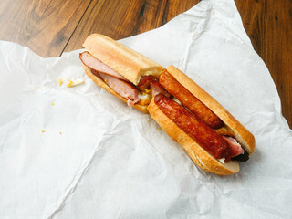Traditional tasty Irish breakfast roll with white bread, sausage, bacon or rasher, fried egg and...