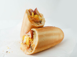 Traditional tasty Irish breakfast roll with white bread, sausage, bacon or rasher, fried egg and...
