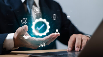 Concept of quality control,certification,quality assurance, service guarantee,businessman working on laptop show management sign according to standard or business process requirement on virtual hand