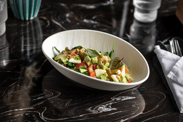 Portion of gourmet salad with avocado and oranges