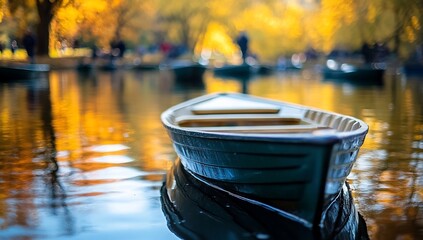 Rowboat on calm autumn lake with blurred background of people and trees.