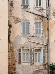Weathered Building Facade with Shuttered Windows