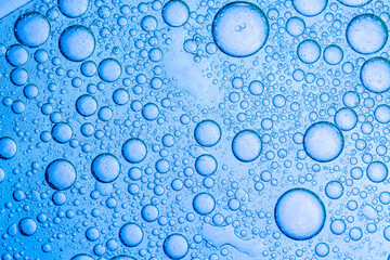 Blue macro serum foam texture,abstract light blue background with oil circles . bubbles of water...