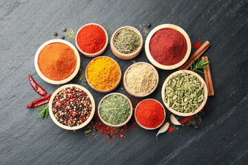 Different aromatic spices on black table, flat lay