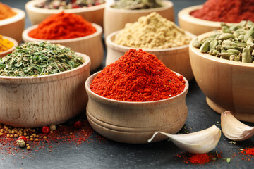 Different aromatic spices on black table, closeup