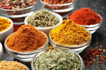 Different aromatic spices in bowls on table, closeup