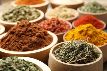 Different aromatic spices in bowls on table, closeup