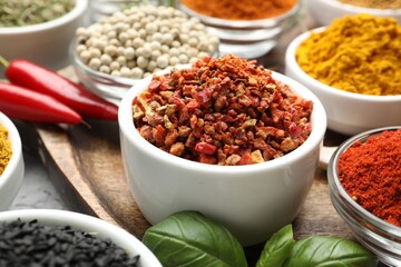 Different aromatic spices in bowls on table, closeup