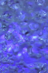 hydrogel balls in blue light abstract background, close up.