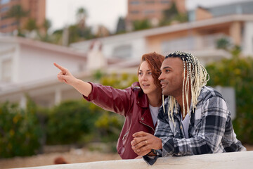 Friends enjoying a sunny day outdoors, pointing at something interesting