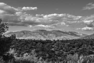 Black and white photo of a mountain landscape with clouds.