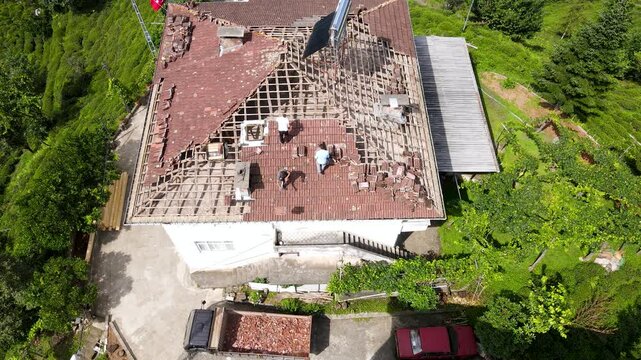The footage of people dangerously repairing a roof without taking any safety precautions.