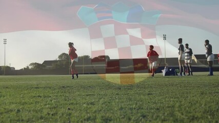 Red-jerseyed rugby player in training approaching ball kicking it for teammate catch then tackle - Powered by Adobe