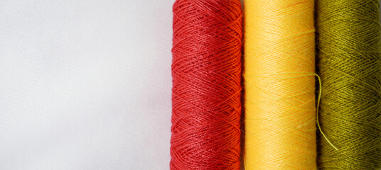 Spool of sewing thread, isolated on white background. Colored yarns used by factories in the clothing industry. Threads wound on the spool. Colored reels. Background and abstract image.