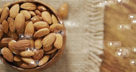 Social media icons fading in over wooden almond bowl, drifting then disappearing showing engagement - Powered by Adobe