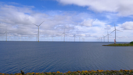 Many wind turbines in the sea. The largest wind turbine park in Holland. The concept of using relatively clean energy from nature for humanity, the so-called green energy.