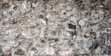 Grey embossed stone in cement wall for abstract background and texture for interior or exterior design. Beautiful patterns, banner, wallpaper close up.