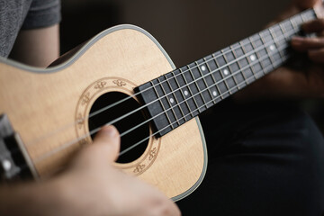 Man learns to play the ukulele. The concept of online learning, home education.
