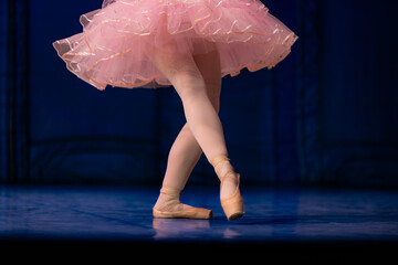 Closeup of ballerina dancing isolated on stage.