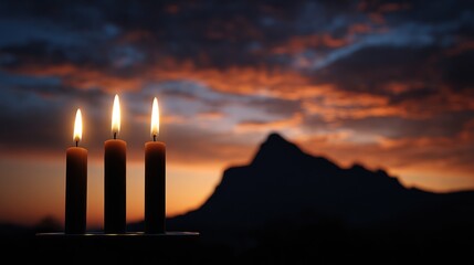 Three Candles at Sunset with Mountain Silhouette