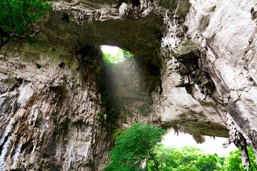 Light shines through the hole of the cave at Tham Than Lot Yai, Chaloem Rattanakosin National Park, Kanchanaburi Province,Thailand.