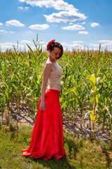 Countryside scene. Folkloric girl. Ethnic and folk. Young woman in cornfield under blue sky....