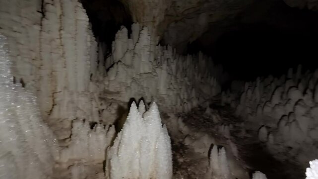 Spectacular view of unique white formations hanging from the ceiling inside a cavern with walls and an underground geological wonderland