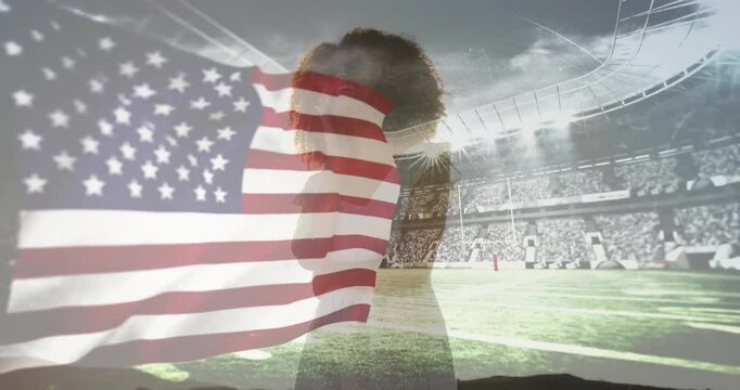 Flag billowing revealing woman singing national anthem in sports stadium under floodlights