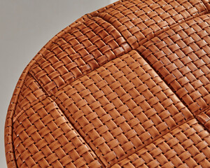 Close-up of woven leather upholstery creating textured surface on round furniture