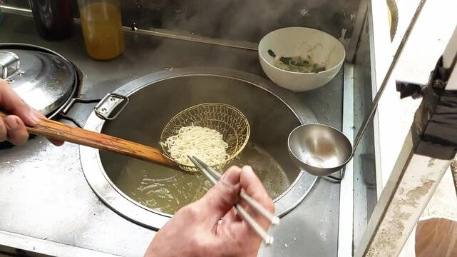 Cinematic shot of serving process of Boiled Noodles, Bakmi Ayam. It served with fresh vegetables, chicken chopped meat and&nbsp;fried&nbsp;dumplings