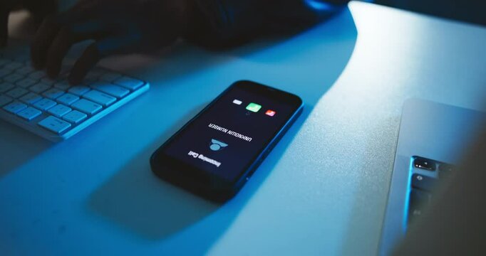 Hands, typing and incoming call with phone screen in office with unknown number, phishing scam or ignore spam at night. Computer, person or cell with private contact for mobile fraud and late scammer