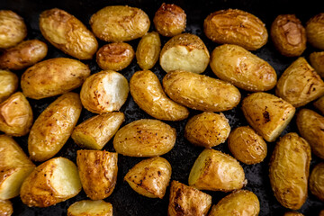 Golden Roasted Baby Potatoes on a Dark Tray Showcasing Crispy Skins and Rustic Texture in a Close-Up Food Photography Perspective