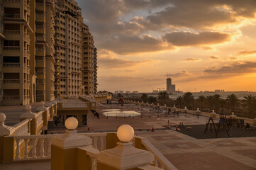 Naklejka premium Sunset above apartment house in Al Hamra, UAE.