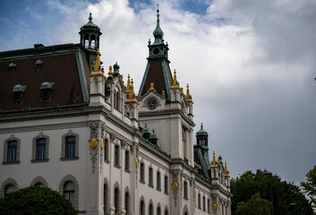 Ornate historical building with intricate architecture and gold accents, set against a cloudy...