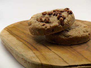 Chocolate chip cookies on a wooden board with a white background