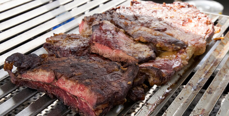 Grilled beef steak pieces on a barbecue grill, showcasing juicy texture and charred surface, perfect for culinary enthusiasts and food photography