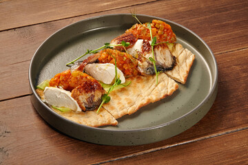 Grilled eel, stracciatella cheese and vegetable relish served on pita bread