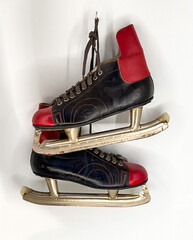 A pair of classic vintage ice skates, featuring striking black leather boots with bold red accents...