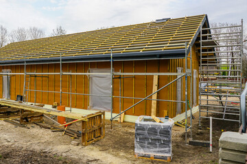 Construction phase of a single story timber framed house, roof structure and wall framework