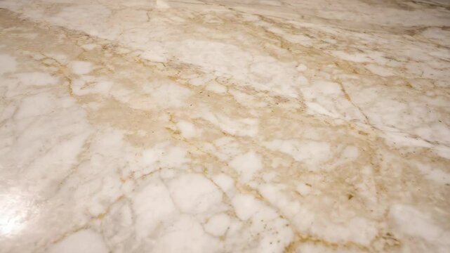 Creamy white marble surface with intricate veins and patterns, creating a luxurious and elegant texture for backgrounds and design projects.