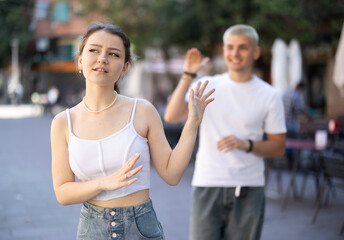 Young woman was offended by her boyfriend. Young couple quarreled on the street.
